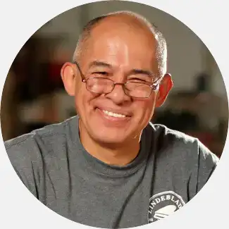 Galo Torres, a soundboard master craftsman, wearing a gray Lindeblad shirt, with 30 years of Steinway factory experience.