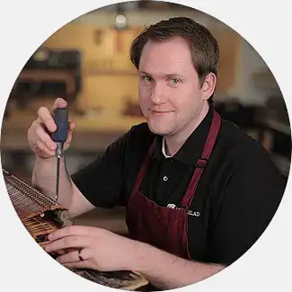 Jon Lindeblad, action regulation craftsman, engaged in rebuilding a piano action, representing the fourth generation of the Lindeblad legacy.