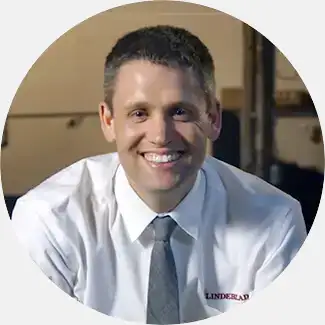 Todd Lindeblad, co-owner and fourth-generation of Lindeblad Piano Restoration, smiling in a white shirt, symbolizing trusted customer service.